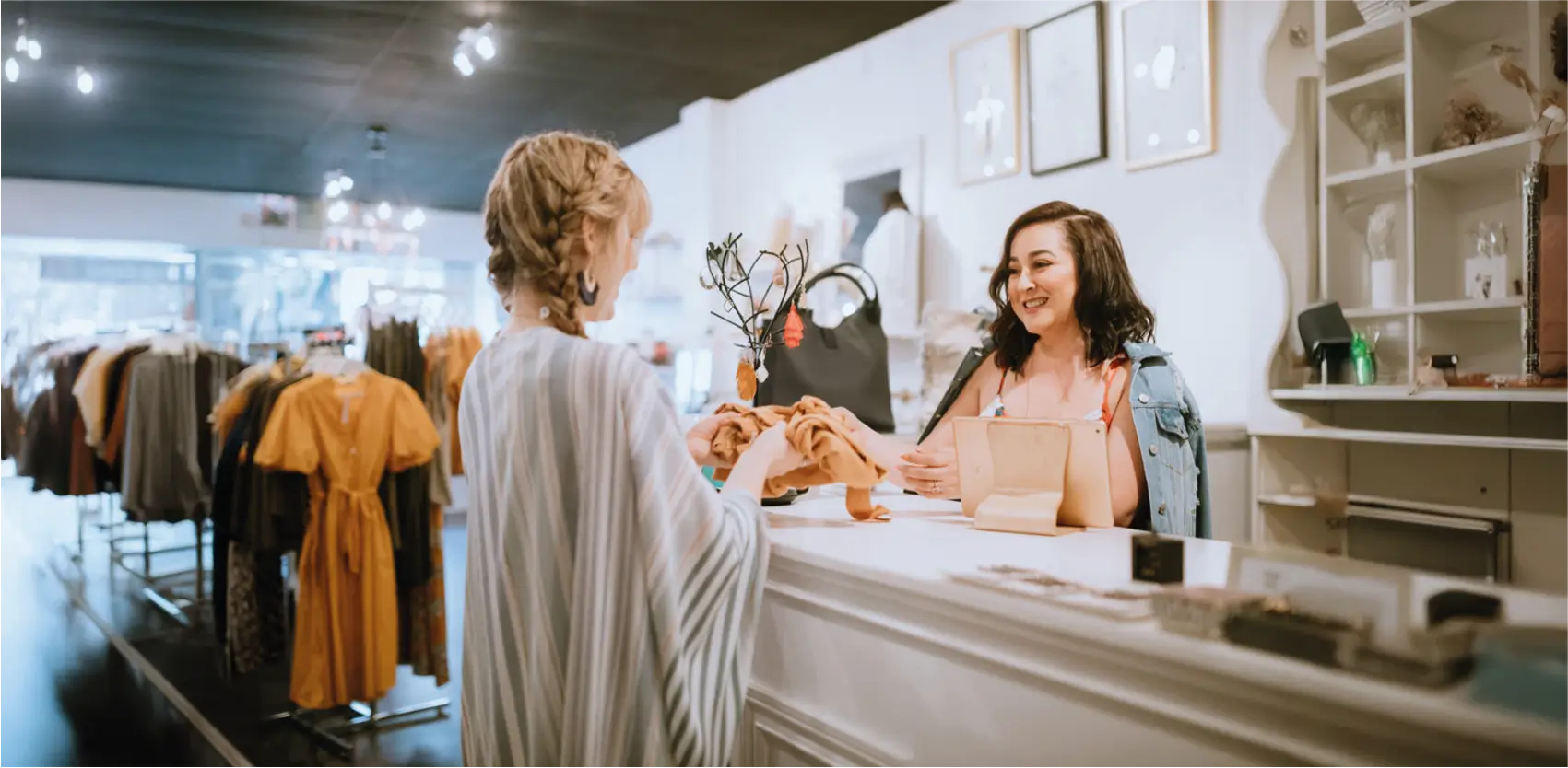 Mostrador comercial en local de ropa con clienta realizando una compra
