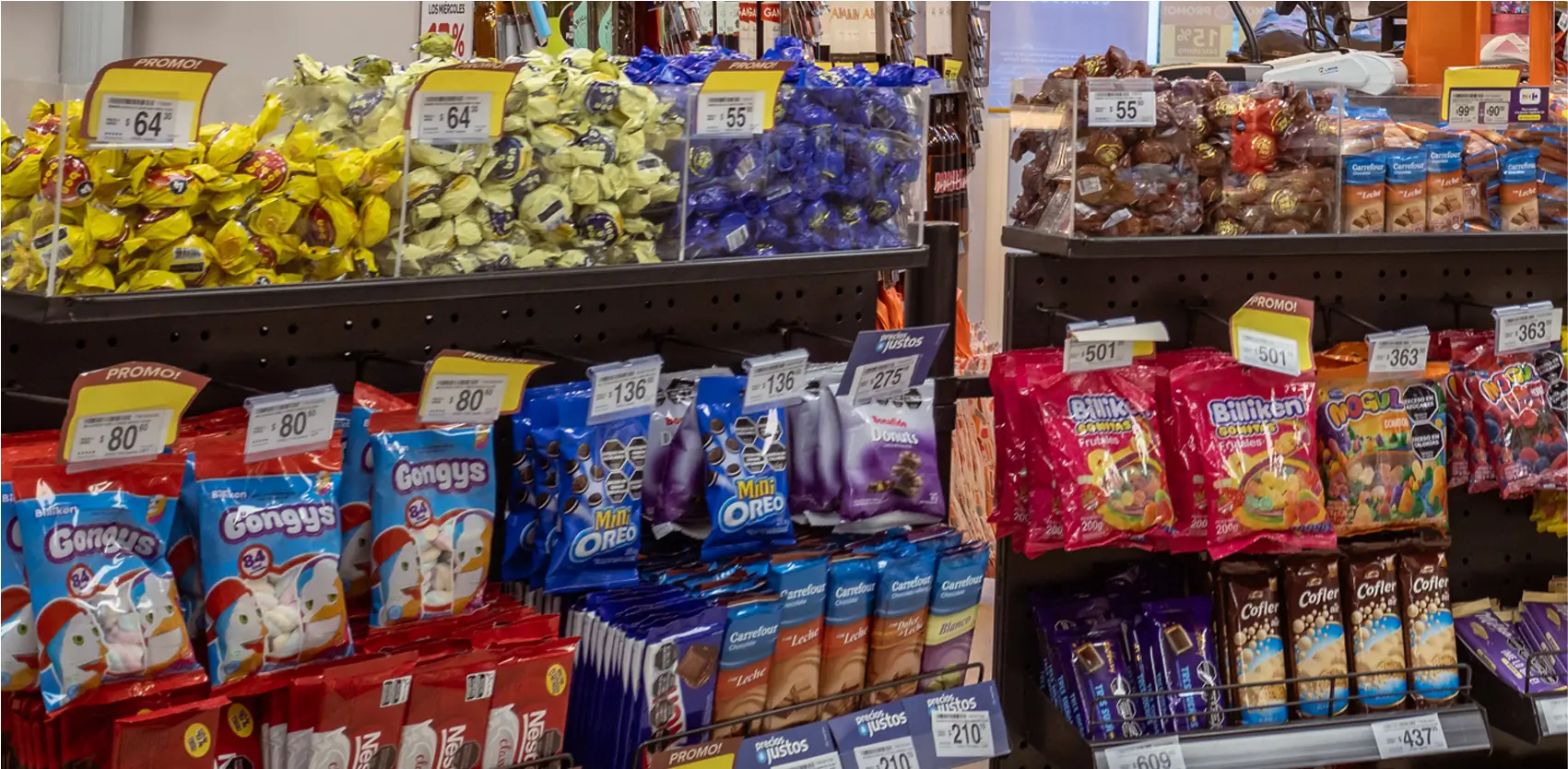 Exhibidor unifila con productos de temporada y promociones impulsivas en supermercado durante el verano