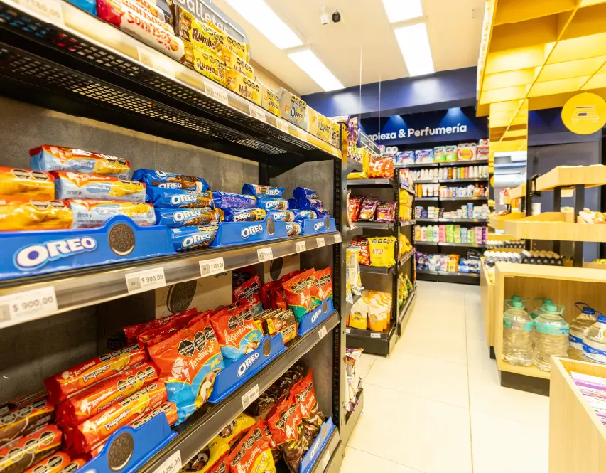 Góndolas con snacks y productos de consumo rápido en tienda de proximidad con layout compacto